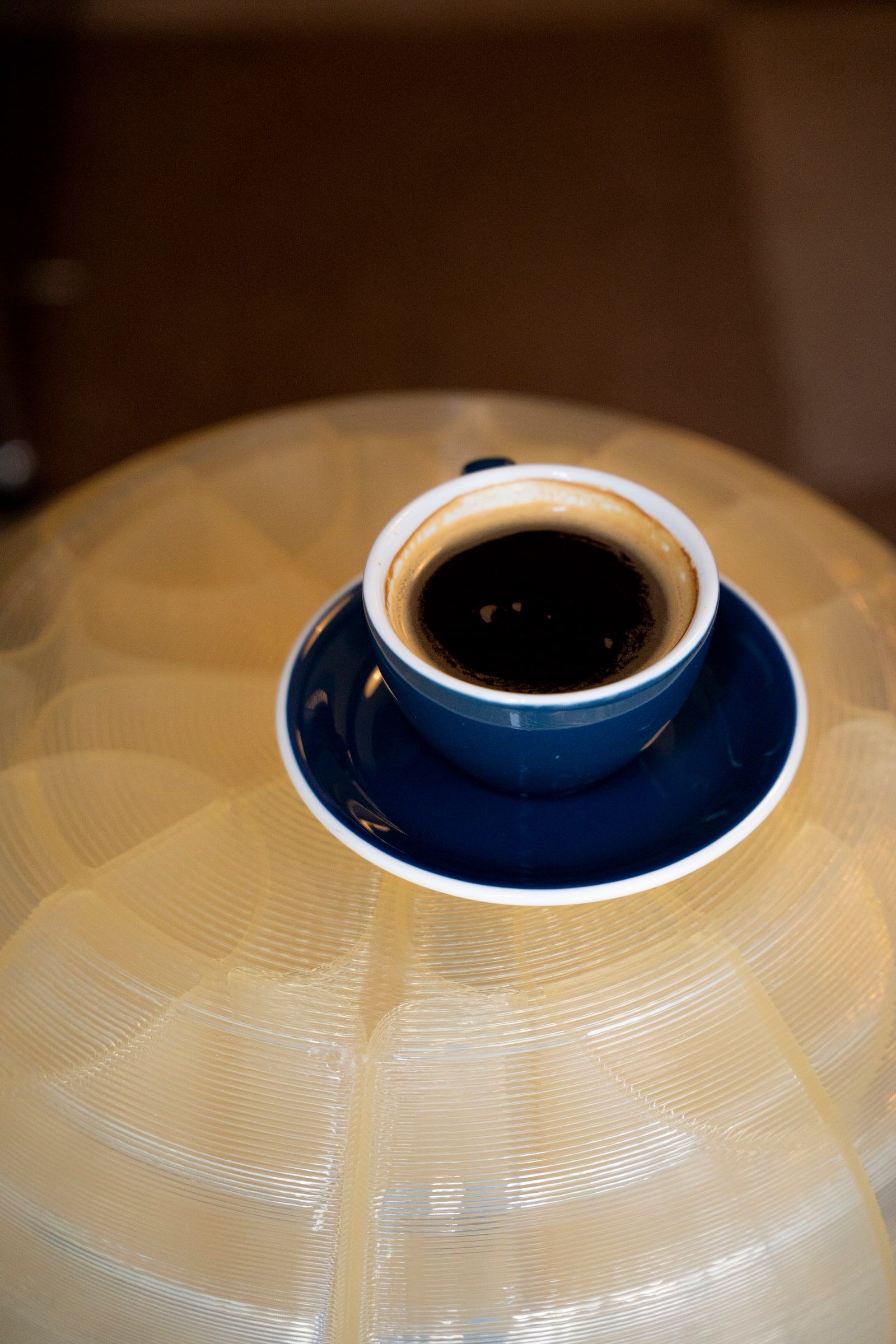 Ein schwarzer Kaffee in einer blauen Tasse mit Untertasse